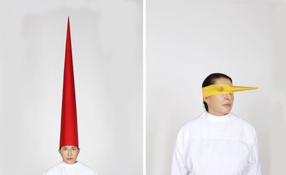 Marina Abramović Energy Clothes exhibition: the artist in white wearing red and yellow hats 